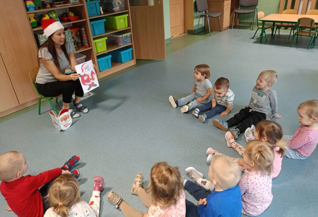 Opiekunka pokazuje obrazki w książeczce