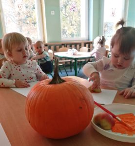 Dzieci robią stemple z jabłka na papierze grupa 2