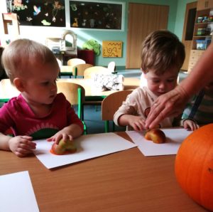 Dzieci robią stemple z jabłka na papierze grupa 2