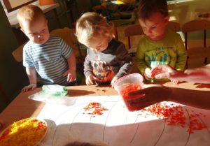 Dzieci wyklejają bibułą dynię grupa 1