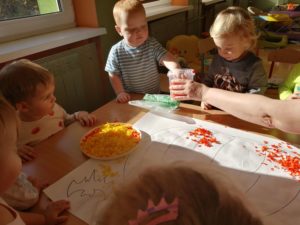 Dzieci wyklejają bibułą dynię grupa 1