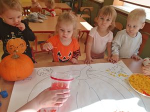 Dzieci wyklejają bibułą dynię grupa 1