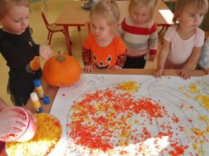 Dzieci wyklejają bibułą dynię grupa 1