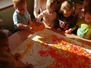 Dzieci wyklejają bibułą dynię grupa 1