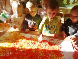 Dzieci wyklejają bibułą dynię grupa 1