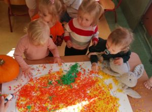 Dzieci wyklejają bibułą dynię grupa 1