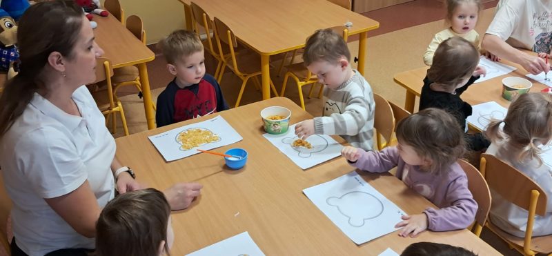 Dzieci wyklejają misie, grupa 3