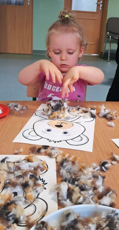 Dzieci wyklejają misie, grupa 2